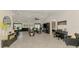 Open-concept living space featuring tile flooring, seamlessly connecting the dining, kitchen, and living areas, bathed in natural light at 1321 Calgary Rd, North Port, FL 34288