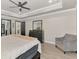 Comfortable main bedroom featuring wood floors, a grey accent chair and views of the ensuite bathroom at 1321 Calgary Rd, North Port, FL 34288