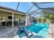 Relaxing screened-in pool area with in-pool seating, dining table, and views of the lush backyard at 1321 Calgary Rd, North Port, FL 34288