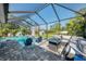 Screened-in pool area with comfortable lounge seating, pool chairs, and lush backyard view at 1321 Calgary Rd, North Port, FL 34288