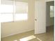 Neutral bedroom featuring bright windows, white door, and tile floors at 139 Dow Rd, Port Charlotte, FL 33952