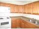 Well-lit kitchen with white appliances, warm wood cabinetry, and durable countertops at 139 Dow Rd, Port Charlotte, FL 33952
