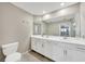 Bathroom with dual sinks, white cabinetry, modern fixtures, and tile flooring with a large vanity mirror at 14271 Heritage Landing Blvd # 1516, Punta Gorda, FL 33955