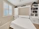 Cozy bedroom featuring a Murphy bed, built-in shelves and drawers, plus a window with plantation shutters at 14271 Heritage Landing Blvd # 1516, Punta Gorda, FL 33955