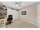 Neutral-toned bedroom with tile floor, ceiling fan, and Murphy bed with shelving plus a comfortable desk and chair at 14271 Heritage Landing Blvd # 1516, Punta Gorda, FL 33955