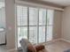 Comfortable living room with tile flooring, chair, and large windows with white plantation shutters at 14271 Heritage Landing Blvd # 1516, Punta Gorda, FL 33955
