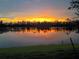 Stunning sunset view over the water, casting vibrant orange and yellow reflections across the tranquil lake at 14271 Heritage Landing Blvd # 1516, Punta Gorda, FL 33955