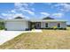 Charming single-story home featuring a two-car garage, well-manicured lawn, and a welcoming front entrance at 16031 Hesta Misty Ct, Punta Gorda, FL 33955