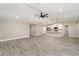 Open-concept living space with gray vinyl flooring and a ceiling fan, connecting seamlessly to the modern kitchen at 16031 Hesta Misty Ct, Punta Gorda, FL 33955