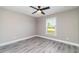 Inviting bedroom with a modern ceiling fan, large window, and neutral gray color scheme at 16098 Overdale Ct, Punta Gorda, FL 33955