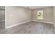 Neutral bedroom featuring gray flooring, white trim, and a window providing natural light at 16098 Overdale Ct, Punta Gorda, FL 33955