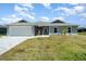 Charming single-story home with a well-manicured lawn, gray siding, and a two-car garage at 16098 Overdale Ct, Punta Gorda, FL 33955