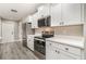 Updated kitchen boasting white cabinets, stainless steel appliances, and gray wood flooring at 16098 Overdale Ct, Punta Gorda, FL 33955
