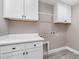 Well-equipped laundry room features white cabinets, countertop, and ample storage space at 16098 Overdale Ct, Punta Gorda, FL 33955