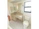 Bathroom featuring a tiled floor, marble countertops, and neutral cabinets with a toilet in the corner at 1612 Blue Lake Cir, Punta Gorda, FL 33983