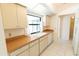Kitchen featuring white appliances, wooden countertops, and access to hallways at 1612 Blue Lake Cir, Punta Gorda, FL 33983