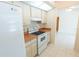 Kitchen featuring white appliances, a white backsplash and a view to an adjacent room at 1612 Blue Lake Cir, Punta Gorda, FL 33983