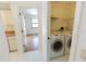 This spacious laundry room features a modern washer and dryer, convenient shelving, and bright tile floors at 1612 Blue Lake Cir, Punta Gorda, FL 33983