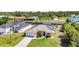An aerial view of a well-maintained home featuring a metal roof, an attached garage, and lush landscaping at 17368 Skipper Ln, Port Charlotte, FL 33948