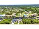 A wide aerial view showcases a community along a waterway surrounded by lush trees and landscaping at 17368 Skipper Ln, Port Charlotte, FL 33948