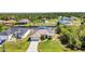Aerial view showcases a single-Gathering home with a metal roof, attached garage, and verdant landscaping at 17368 Skipper Ln, Port Charlotte, FL 33948