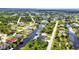 Panoramic aerial view of a community with homes along winding canals, abundant green space, and a distant ocean horizon at 17368 Skipper Ln, Port Charlotte, FL 33948