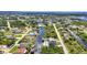An aerial view of a neighborhood with canal-front homes, showcasing lush landscapes and beautiful waterfront living at 17368 Skipper Ln, Port Charlotte, FL 33948