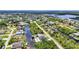 Scenic aerial shot of a residential area with waterfront homes, serene canals, mature trees, and an ocean view in the background at 17368 Skipper Ln, Port Charlotte, FL 33948