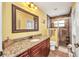 Bathroom featuring granite counters, wood cabinets, and a glass door shower with tiled walls at 17368 Skipper Ln, Port Charlotte, FL 33948