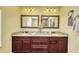 Bathroom showcasing a double vanity with granite countertops and framed mirrors at 17368 Skipper Ln, Port Charlotte, FL 33948