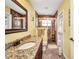 Bathroom featuring granite counters, wood cabinets, and a glass door shower with tiled walls at 17368 Skipper Ln, Port Charlotte, FL 33948