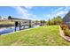 Waterfront backyard with a covered boat dock along the canal and well-maintained lawn at 17368 Skipper Ln, Port Charlotte, FL 33948