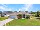 Charming single-story home featuring a well-manicured lawn, attached garage, and beautiful landscaping at 17368 Skipper Ln, Port Charlotte, FL 33948