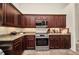 Modern kitchen with granite countertops, stainless steel appliances, and dark wood cabinets at 17368 Skipper Ln, Port Charlotte, FL 33948