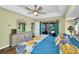 A stylish primary bedroom with tray ceilings, a ceiling fan, and sliding glass door to the outdoor living space at 17368 Skipper Ln, Port Charlotte, FL 33948