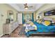 A stylish primary bedroom with tray ceilings, a ceiling fan, and sliding glass door to the outdoor living space at 17368 Skipper Ln, Port Charlotte, FL 33948