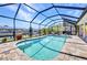 Gorgeous screened-in pool features a brick patio, sun loungers, and relaxing canal view at 17368 Skipper Ln, Port Charlotte, FL 33948