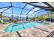 A crystal-clear, screened-in private pool with brick patio, seating, and canal views at 17368 Skipper Ln, Port Charlotte, FL 33948