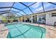Relaxing screened pool area with patio, lounge chairs, and views of the backyard and canal at 17368 Skipper Ln, Port Charlotte, FL 33948