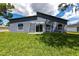 Lush backyard featuring modern exterior, well-maintained lawn, and glass sliding doors for seamless indoor-outdoor living at 19160 Ruskin Ave, Port Charlotte, FL 33954