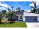 Contemporary home featuring a modern design, a well-manicured lawn, and a stylish two-car garage at 19160 Ruskin Ave, Port Charlotte, FL 33954
