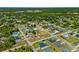 Aerial view of a light blue single Gathering home in a lush, green neighborhood under a clear blue sky at 1981 Arena Ln, North Port, FL 34286