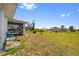 View of a light blue single-Gathering home with a screened in lanai and a spacious backyard on a beautiful day at 1981 Arena Ln, North Port, FL 34286