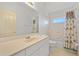Bright bathroom featuring a vanity and a tub with floral shower curtain at 1981 Arena Ln, North Port, FL 34286