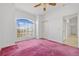 Bright bedroom with pink carpet and arched window with closet at 1981 Arena Ln, North Port, FL 34286