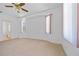 Neutral carpeted main bedroom featuring a ceiling fan and bright windows with blinds at 1981 Arena Ln, North Port, FL 34286