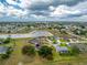 Expansive aerial shot showcasing a property with mature trees, lush landscaping, and a serene lake in the distance at 2168 Calcutta Rd, Punta Gorda, FL 33983