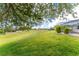 Lush backyard showcasing the well-manicured lawn and screened-in patio with mature landscaping at 2168 Calcutta Rd, Punta Gorda, FL 33983