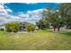 Large backyard featuring grass, trees, and a screened-in patio at 2168 Calcutta Rd, Punta Gorda, FL 33983