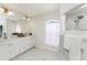 Well-lit bathroom with dual sinks, arched window, and tiled shower at 2168 Calcutta Rd, Punta Gorda, FL 33983